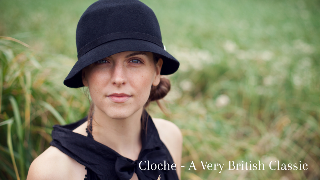 A lady in a field wearing a classic black cloche hat, black long gloves and a timeless looking sleeveless black dress.
