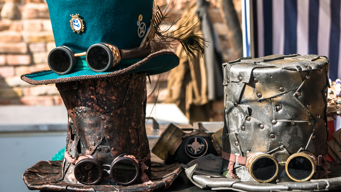 Three steampunk hats with goggles on a table