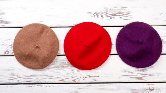 Three berets hanging on hooks, in a row