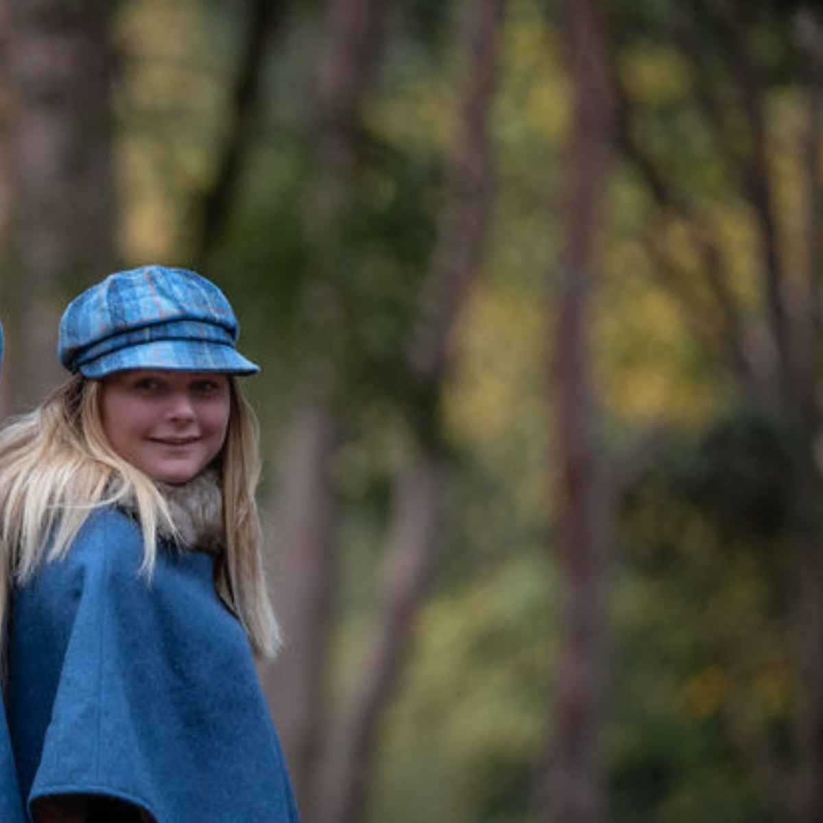 Young girl wearing a baker boy style cap, in the woods