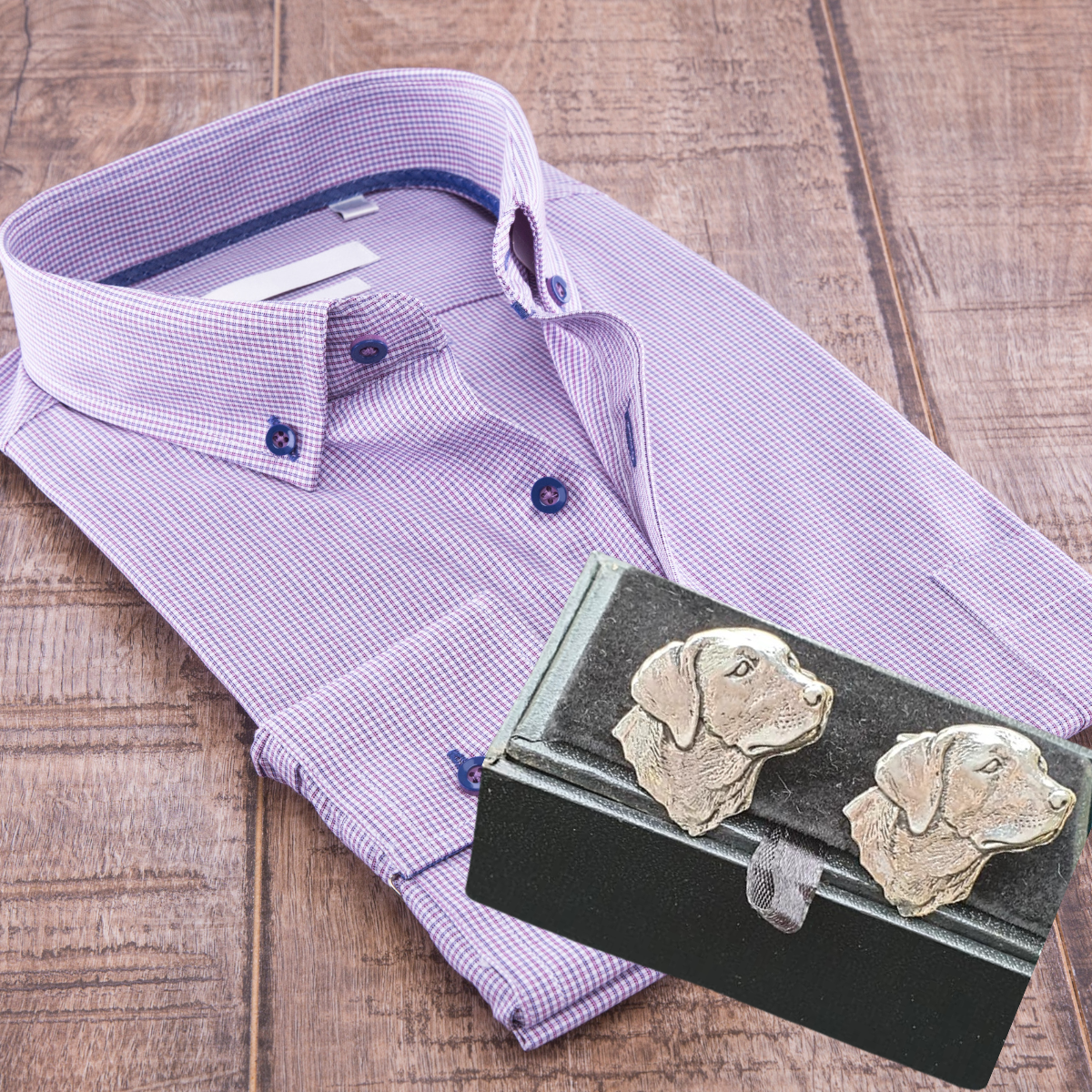 Dog head cufflinks sitting on a folded man's formal shirt