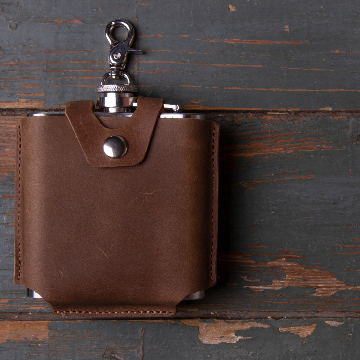Stainless steel hip flask with leather trim and cartridge detail. Perfect for whiskey, bourbon, or other spirits.