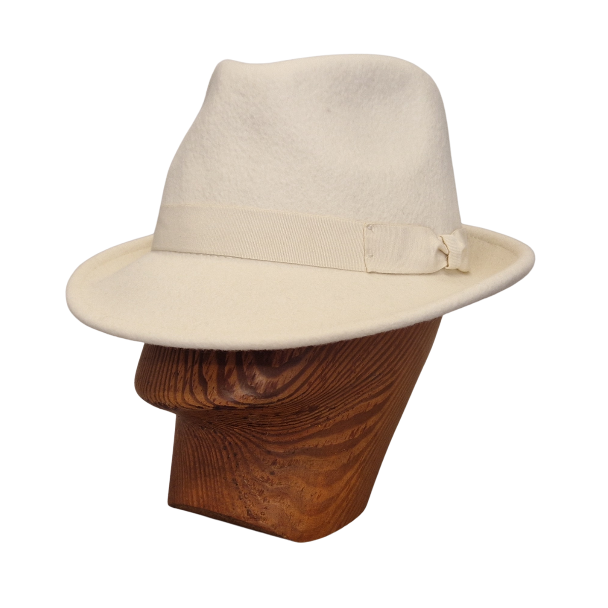 A cream felt trilby hat with a matching band and bow, displayed on a brown wooden mannequin head against a white background. Front side.