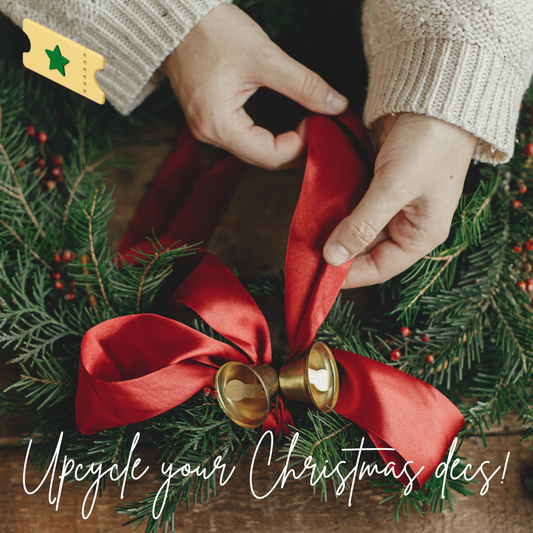 Hands tying a new red ribbon to a wreath